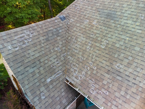 Roof with hail damage and chalk markings from inspection