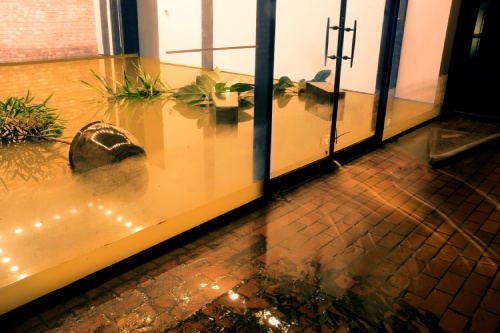 Water flowing through doors from a flooded office. Effects Tropical depression Imelda. Houston, Texas, US