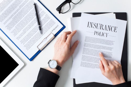 Business woman showing insurance document over white desk at office