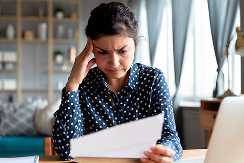 woman checking paper with confusing face