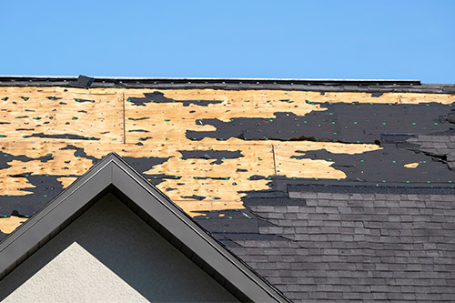 Close-up of a roof showing damaged shingles, emphasizing the importance of timely claims for hail damage in Cedar Park.