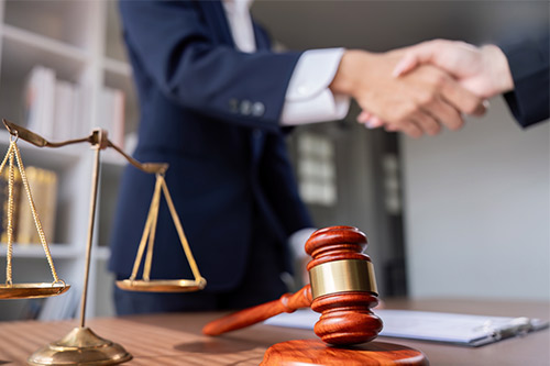 A lawyer shakes hands with a judge, representing a pivotal moment in a Texas property damage settlement discussion.