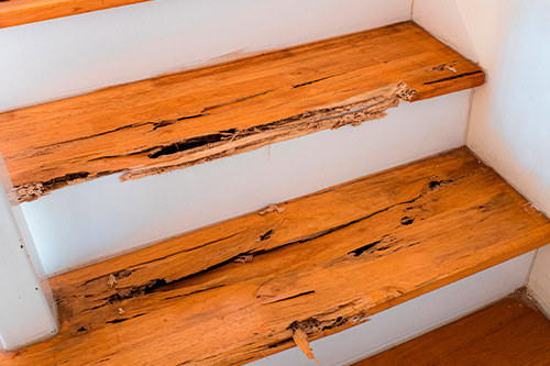A wooden staircase featuring a broken handrail, illustrating a hidden danger that may lead to slip and fall injuries.