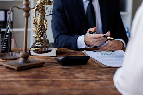A man in a suit and a woman sit at a desk, engaged in a conversation about the complexities of truck accident claims.