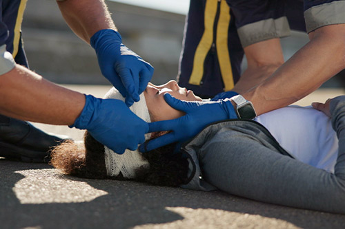 Paramedics treating a woman in need of medical assistance, showcasing the urgency of emergency care in critical situations.