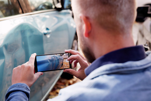 Insurance Investigator Captures Evidence Of Car Accident Aftermath On Smartphone.
