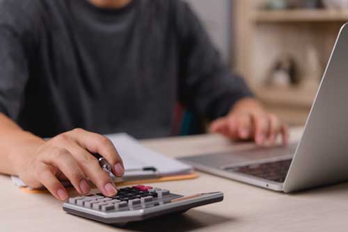 Businessman using calculator bookkeeping payroll and budget tax. Business document finance accounting investment digital workflow and financial planning.
