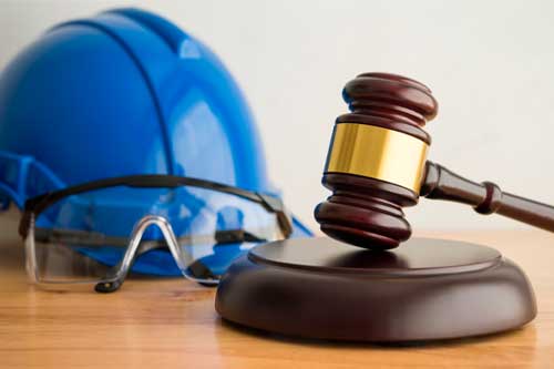 Hammer judge gavel with construction hat helmet, worker safety glasses on wooden background. Labour law concept. Wages, overtime pay, welfare, occupational safety, health, environment, severance pay.