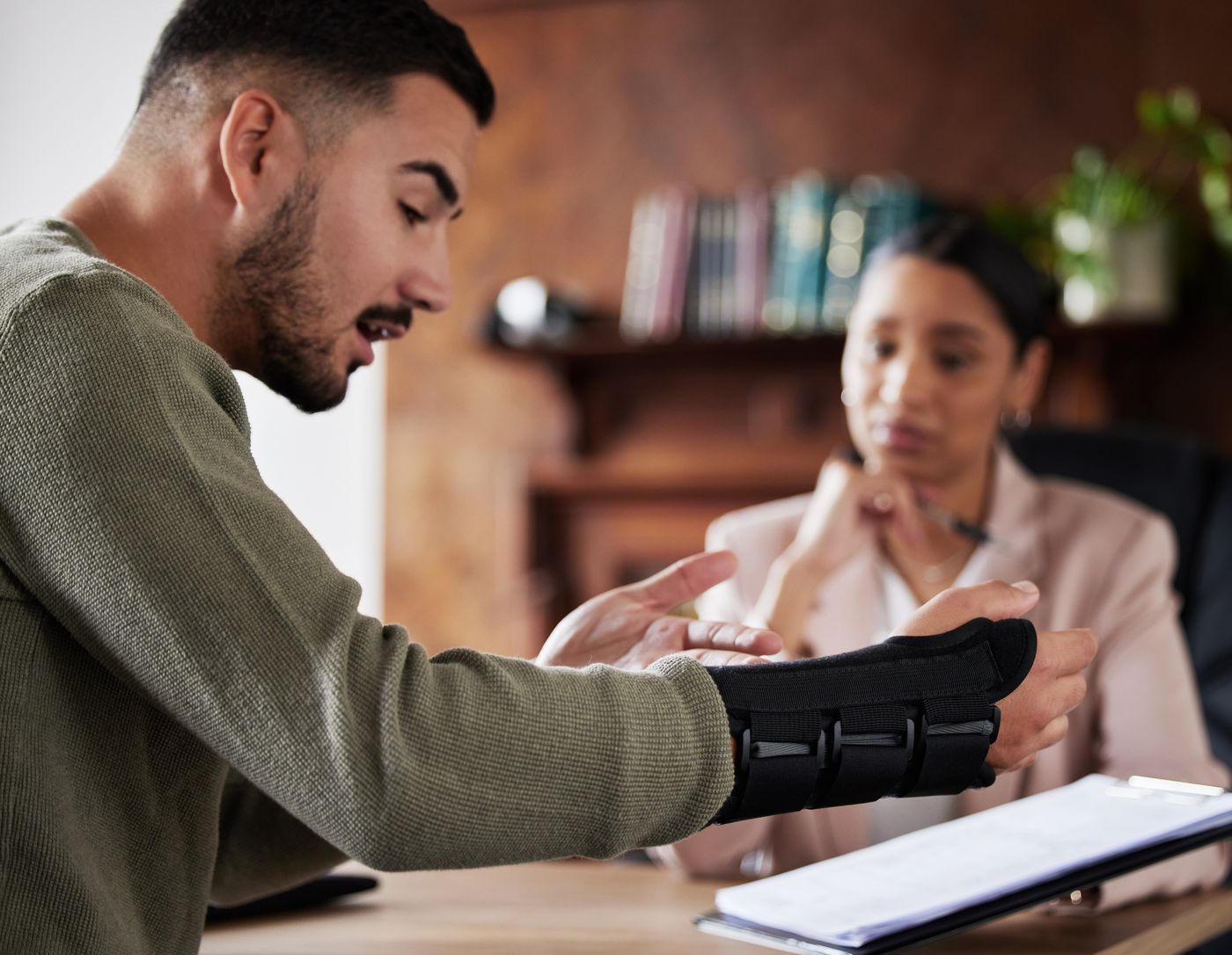 Injured client with a wrist brace meeting with a Palker Law attorney